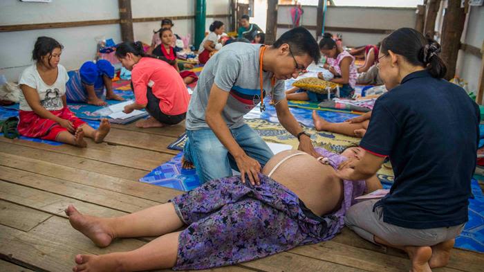 Health care workers checking a pregnant woman