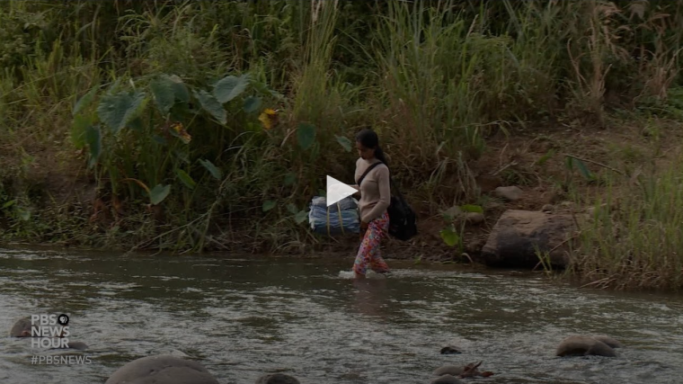 Woman crossing a river in Cambodia