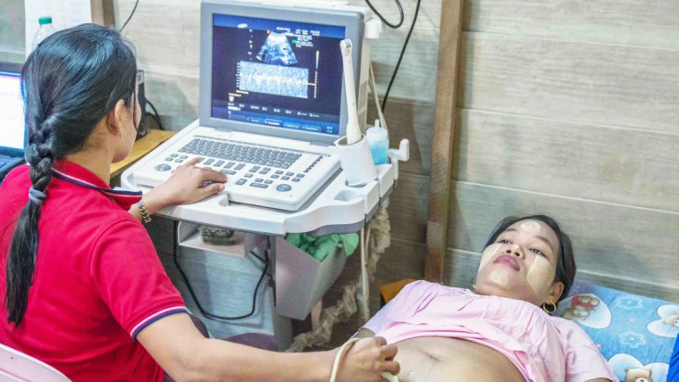 Healthcare worker performing an ultrasound on a pregnant woman