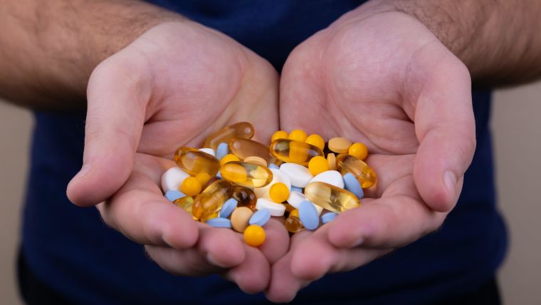 Hands holding a multitude of pills