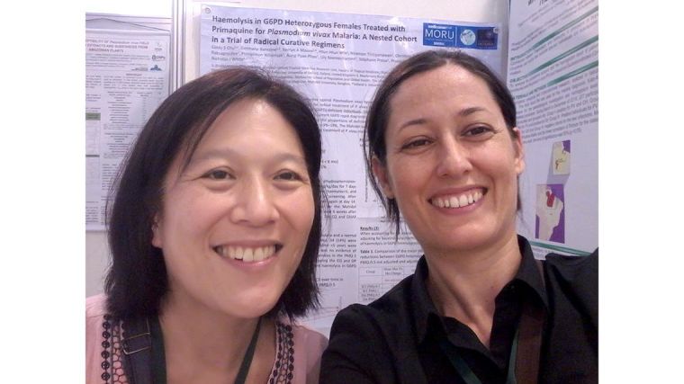 Germana Bancone and Cindy Chu, standing in front of posters at a conference