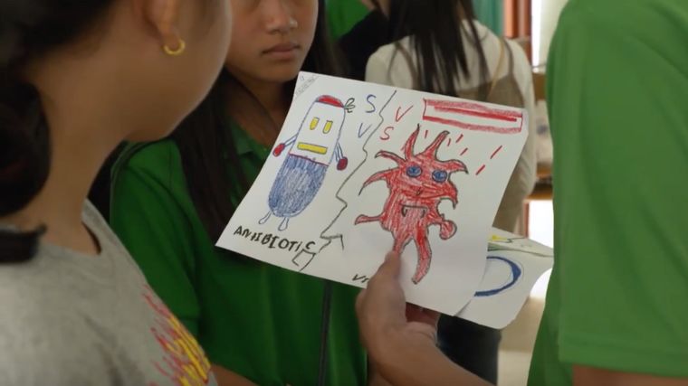 Woman being shown drawing of an antibiotic and a virus