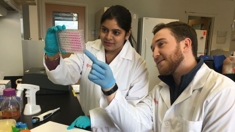 Photo of postdoc researcher Sarmistha Guha and Edward Leithead in a lab at Rutgers University